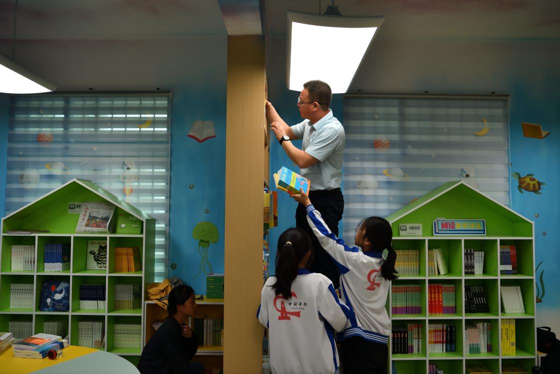 于都县岭背镇中心小学老师和同学们一起布置新的阅读室.jpg
