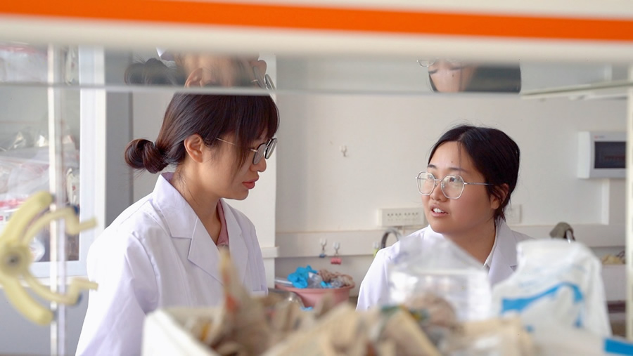 王海丹（右）与同事在实验室探讨包材问题.jpg