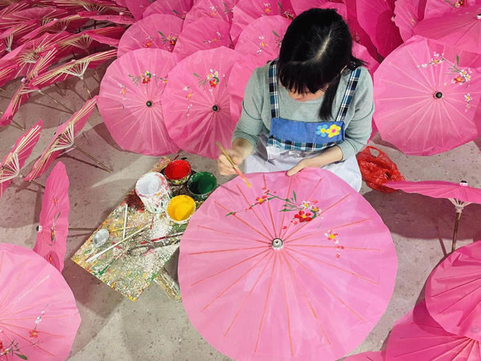 周汉宇将以齐白石为代表的湘潭民间绘画风格移植到石鼓油纸伞的伞面上，完成油纸伞从实用到艺术的功能转型.jpg